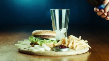 Hamburger sandviç ve tepside patates kızartması.