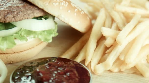 Hamburgare en smörgås stekt pommes frites på ett bord — Stockvideo