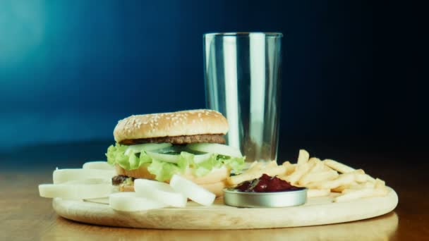 Hamburger een broodje en frietjes op een dienblad — Stockvideo