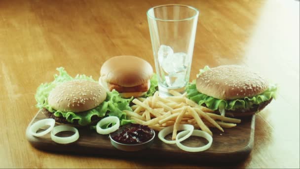 Hamburgare en smörgås och pommes frites på en bricka — Stockvideo