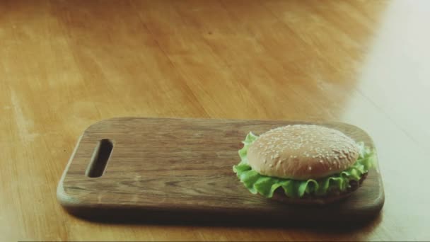 Hamburgare en smörgås och pommes frites på en bricka — Stockvideo