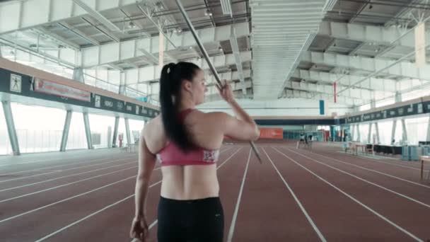 Uma mulher caucasiana lança dardo no estádio — Vídeo de Stock