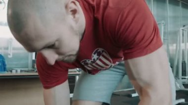 Atlet vücut geliştirmeci kilo halter çubuk üzerinde giderir.