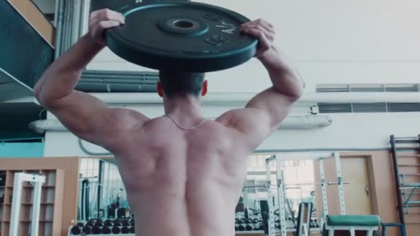 Bodybuilder hace ejercicio rotatorio con barra — Vídeos de Stock