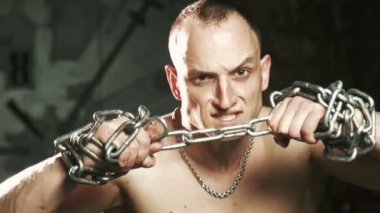 Thorn için metal zincir çalışan genç kel adam