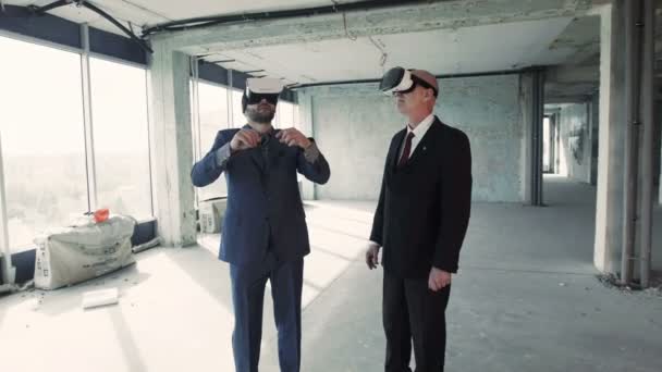 Affärsmän i oculus rift tittar på projekt av framtida byggnad — Stockvideo