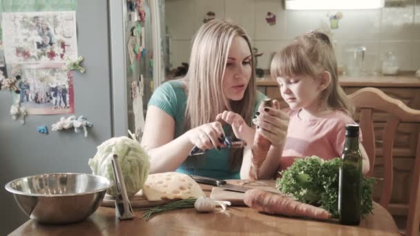 Madre pelando zanahoria con hija — Vídeo de stock