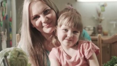 Gülümseyen anne ve kızı sarılma ve öpüşme