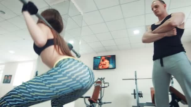 Coach kijken Sportvrouw doen squats met bar — Stockvideo