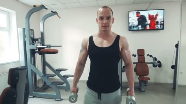 Сильний спортсмен носить гантелі — стокове відео