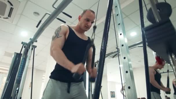 Sportsman doing exercise on triceps with rope — Stock Video