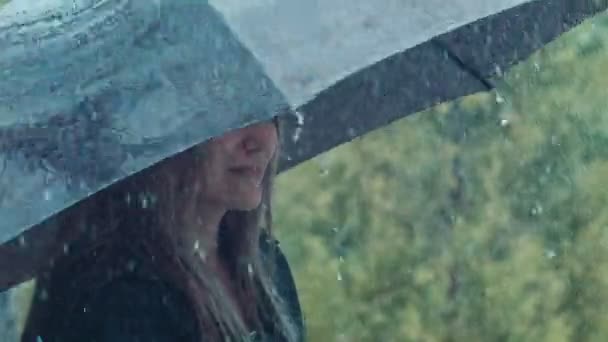 Mulher loira torcendo guarda-chuva sob chuva — Vídeo de Stock