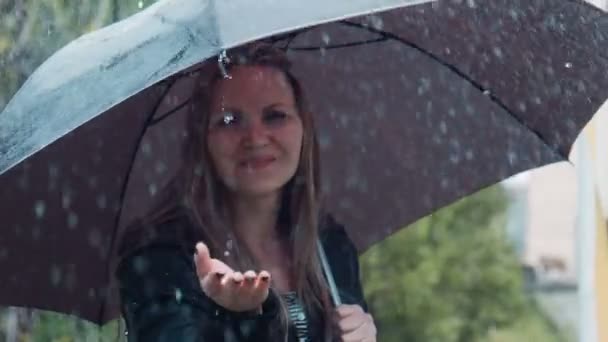 Счастливая женщина играет с капли дождя — стоковое видео