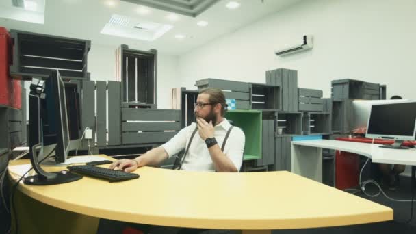 Hombre trabajando en la computadora y hablando con su colega con la tableta — Vídeo de stock