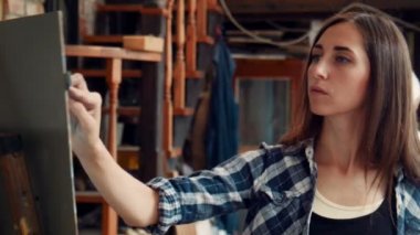 Genç kadın bir stüdyoda bir tuval boyama