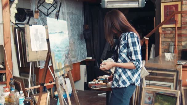 Artista de pie frente a la pintura en el estudio — Vídeo de stock