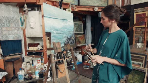 Artista de pie frente a la pintura en el estudio — Vídeo de stock