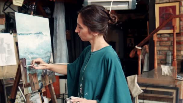 Retrato de una joven pintando un lienzo en un estudio — Vídeos de Stock