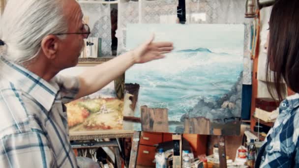 Artistes qualifiés discutant d'une peinture en atelier — Video