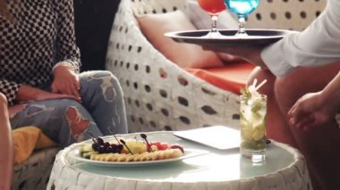 Garson otlu içki küçük yuvarlak masa yerleştirir.