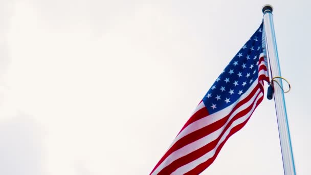 Bandera de los Estados Unidos ondeando desde un asta de bandera — Vídeos de Stock