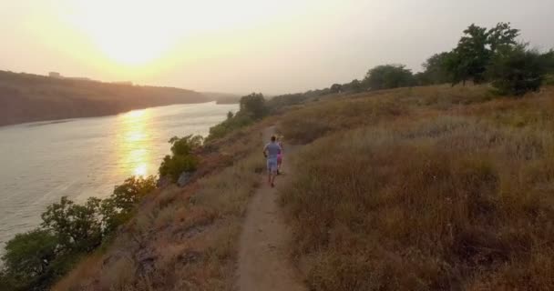 Pareja en forma trotando juntos en un sendero en el campo — Vídeo de stock