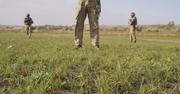 Soldados armados de pie soleado campo verde — Vídeos de Stock