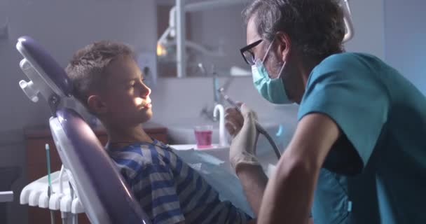Dentista explicando tratamento para paciente adolescente — Vídeo de Stock