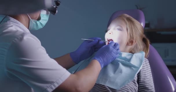 Tandläkare undersöker tänder barn — Stockvideo