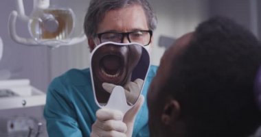 Klinikteki siyahi adama danışan dişçi