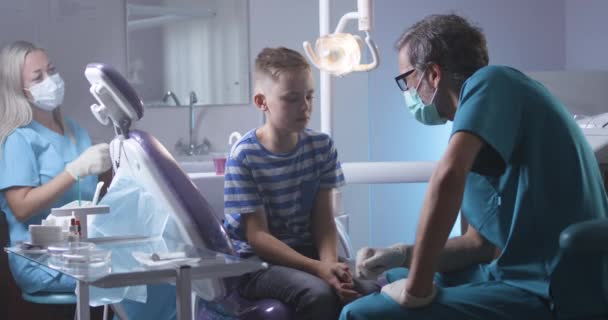 Doctor explaining teeth treatment to kid — Stock Video