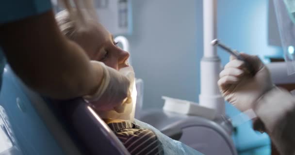 Cesur küçük kız, dişçi muayenesi sırasında sandalyede. — Stok video