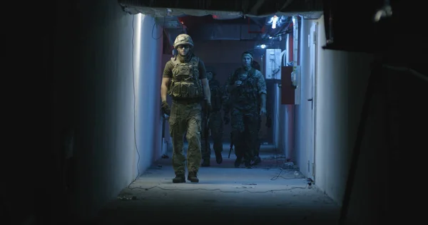 Profesjonalny zespół SWAT spacerujący po ciemnym korytarzu — Zdjęcie stockowe