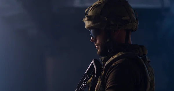 Voják míří pistolí v tmavé chodbě — Stock fotografie