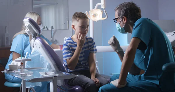 Lekarz wyjaśniający leczenie zębów dziecku — Zdjęcie stockowe