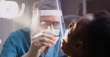 Olgun dişçi hastaya tedavi stratejisini açıklıyor