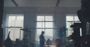 Erkek esnaf karanlık stüdyoda çalışıyor.