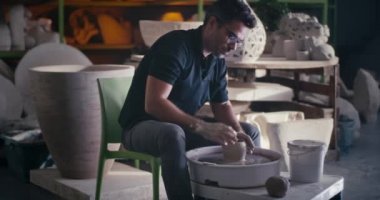 Odaklanmış çömlekçi tekerlek üzerinde vazo yapıyor