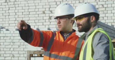 İnşaat alanını meslektaşına gösteren kişi