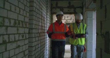 Bitmemiş binayı inceleyen tabletli müteahhitler