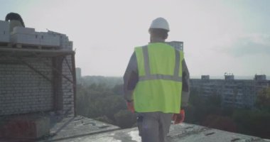 İnşaat alanından şehre bakan bir inşaatçı