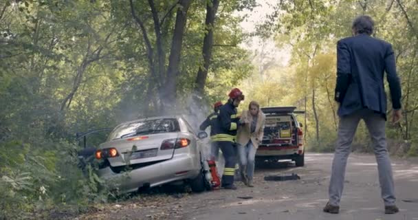 Brandmän rädda kvinna från bil nära mogen man — Stockvideo