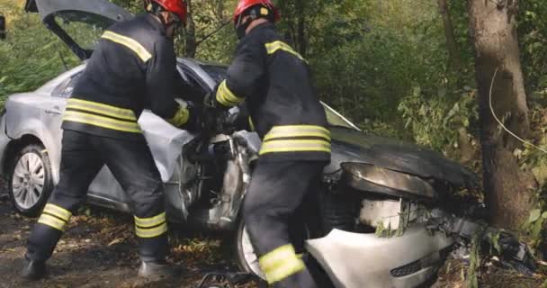 Bomberos desmontando vehículo roto después del accidente — Vídeo de stock