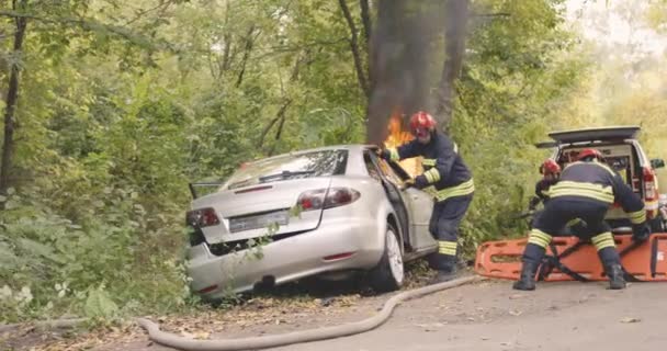 Brandweermannen redden koppel uit brandende auto — Stockvideo
