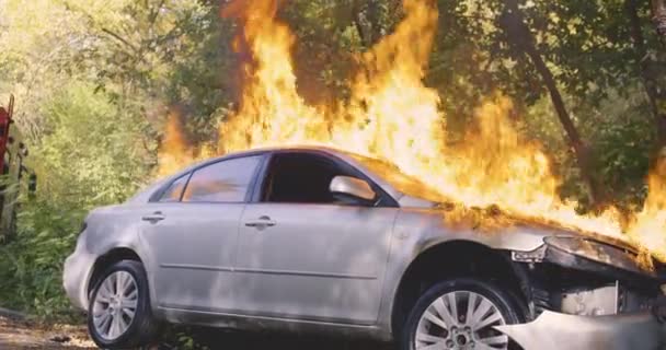 Tanınmayan itfaiyeciler arabayı yangından kurtarıyor. — Stok video