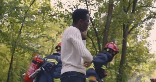 Víctima negra herida mostrando a bomberos estrellados — Vídeos de Stock