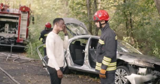 Firefighter questioning black victim of car crash — Stock Video