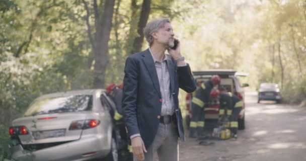 Dojrzały mężczyzna mówi na smartfonie po wypadku drogowym — Wideo stockowe