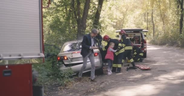 Strażacy ratujący rodzinę po wypadku drogowym — Wideo stockowe