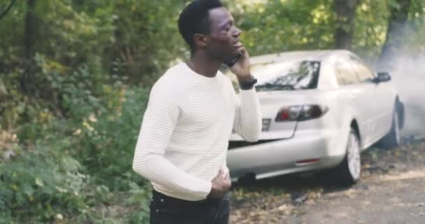 Black survivor making phone call after car crash — Stock Video